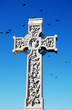 a cross, birds and a blue sky