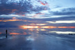person watching sunset over wet salt flats person watching sunset over wet salt flats