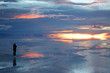 person watching sunset over wet salt flats person watching sunset over wet salt flats