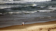 older couple walking along the shore 2
