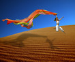 rainbow woman jumping over the dunes