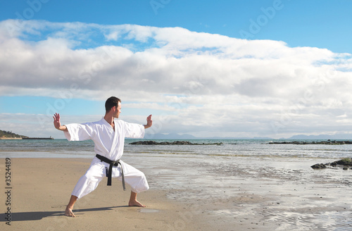 Photo: Man practicing Karate on the beach Man practicing Karate on the beach