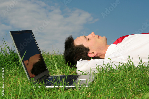 man lying on the grass with laptop man lying on the grass with laptop