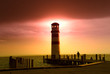 Lighthouse at an Austrian lake with a woman walking towards it