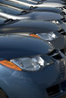 A lineup of new cars at a dealership.