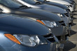 A lineup of new cars at a dealership.