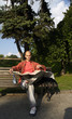 Young male sitting on bench and reading city map.