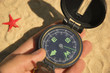 Compass,hand,red star on sand