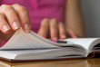 Young female opens notebook and planning her schedule.