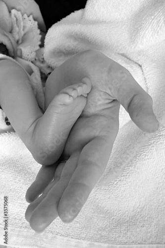 foot of newborn baby held in mother's hand 