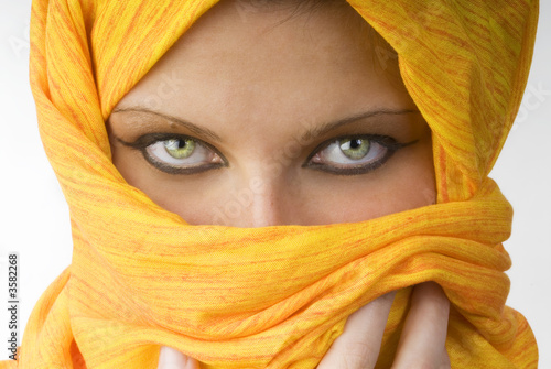 Foto: attactive and strong eyes behind an orange scarf attactive and strong eyes behind an orange scarf