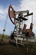 Photo: Rusty pump and old oilwell on the landscape Rusty pump and old oilwell on the landscape