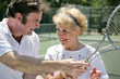  tennis pro gives pointers to older lady