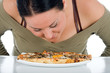 Cute chubby smell the pizza by the table