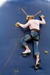 teen-ager girl climbing a wall to reach the top
