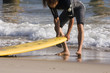 Surfer checking on his board