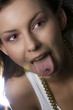 Attractive young woman sticking out her tongue to show piercing Attractive young woman sticking out her tongue to show piercing