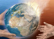 Flaming earth being handed from adult hands to child hands