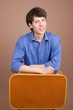 Young traveller with suitcase isolated on beige background