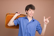 Young traveller with suitcase isolated on beige background