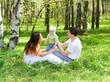 Family at nature. Three persons. Grass. Green forest.