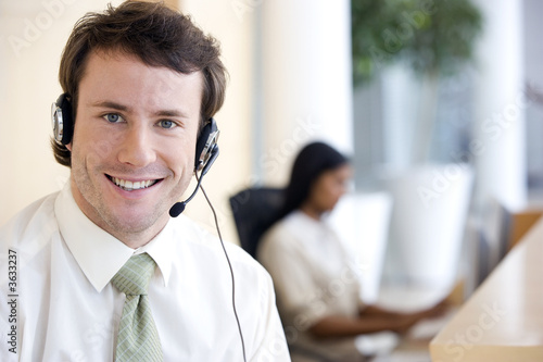 Foto: Young businessman with headset in office Young businessman with headset in office