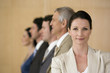 Confident businesswoman with team behind