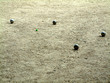 Boules de pétanque et cochonnet vert.