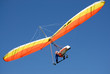 Orange-yellow hang-glider in the steep turn