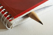 Wooden pencil sticking out spiral bound notebook. Room for text