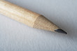 Macro of wooden pencil on blank white sheet of paper..