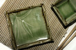 Square sushi plates with chopsticks on a bamboo mat