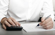 Foto: A businessman calculating expenses at tax time A businessman calculating expenses at tax time