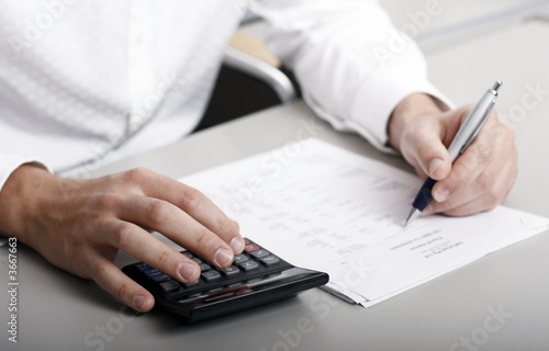 Foto: A businessman calculating expenses at tax time A businessman calculating expenses at tax time