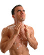 A muscular young man splashing water on his face