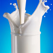 Pouring milk in glass with a splash
