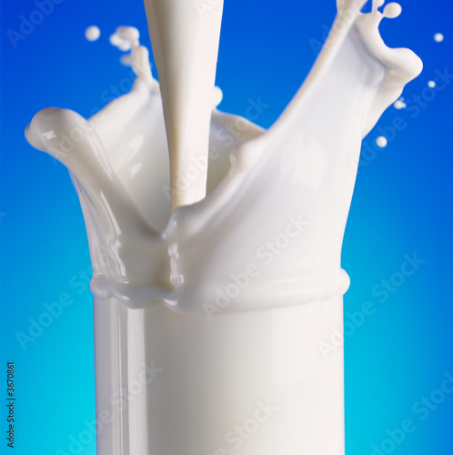 Pouring milk in glass with a splash Pouring milk in glass with a splash