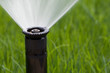 Detail of a working lawn sprinkler head watering the grass Detail of a working lawn sprinkler head watering the grass