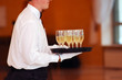waiter with dish of vine glasses