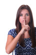 young brunette holding finger to her lips, isolated on white