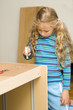 Girl helping to assemble a new furniture Girl helping to assemble a new furniture