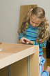 Girl helping to assemble a new furniture Girl helping to assemble a new furniture