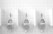 Photo: A row of three public urinals A row of three public urinals