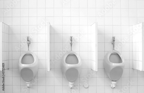 Photo: A row of three public urinals A row of three public urinals