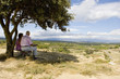 Old couple sitting on a bench, watching at the landscape