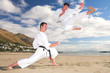 men with black belt practicing Karate on the beach 