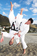 Young adult men with black belt practicing fighting 