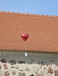 Herzballon vor Kirchendach