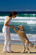 Foto: Young female dancing on a beach with a dog Young female dancing on a beach with a dog