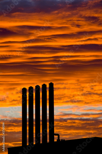 Photo: Backlit chimneys against fiery red dawning Backlit chimneys against fiery red dawning